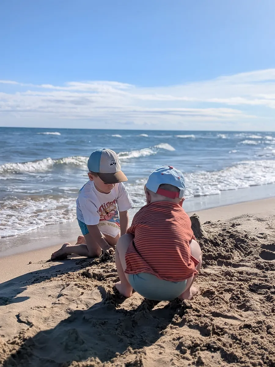 Children playing together in the sand at the beach
