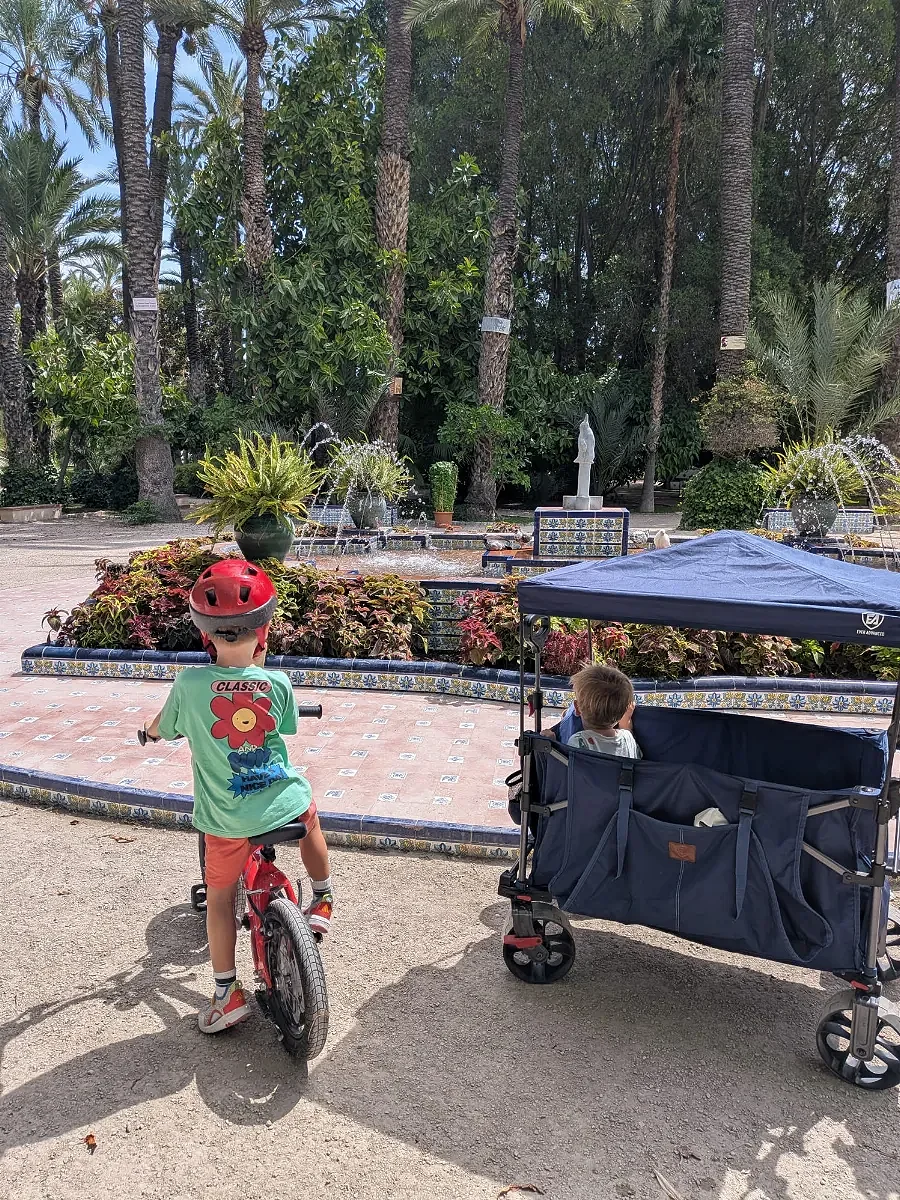 Children enjoying a family outing beside garden fountains