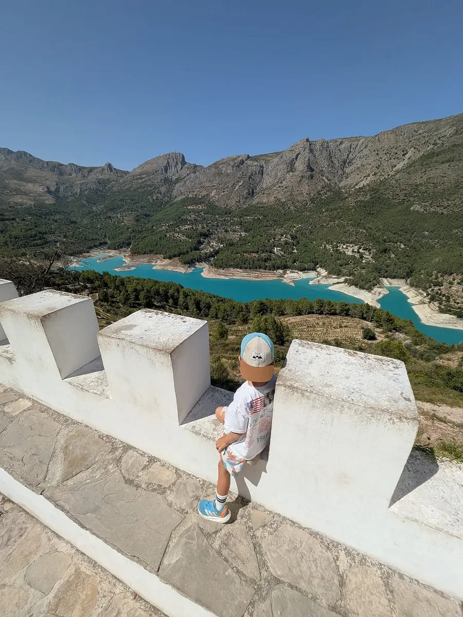 A child enjoying a view of a lake and mountains