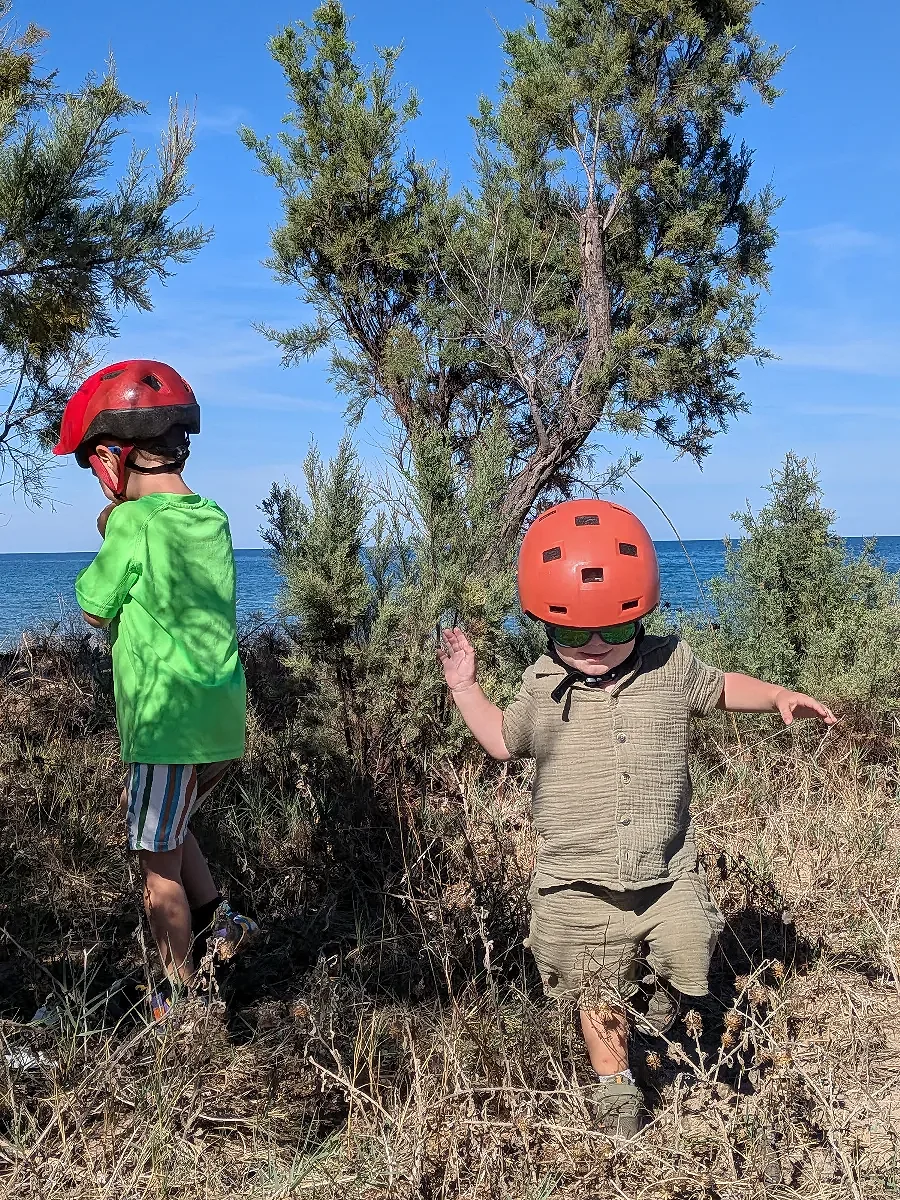 Children exploring outdoors wearing cycling helmets